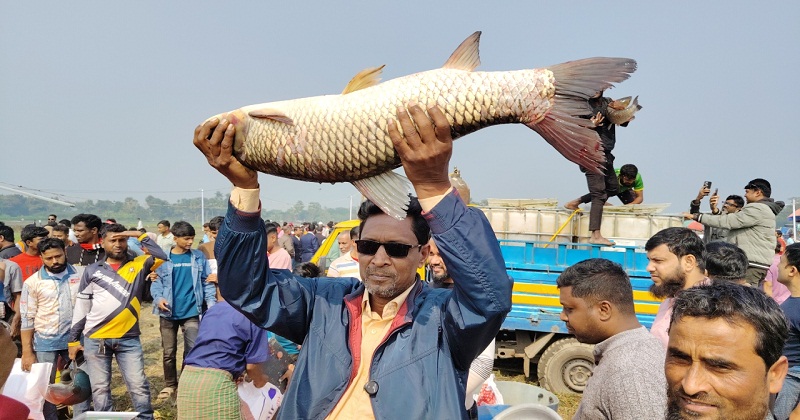 বড় মাছ হাতে মেলায় আগত ক্রেতা