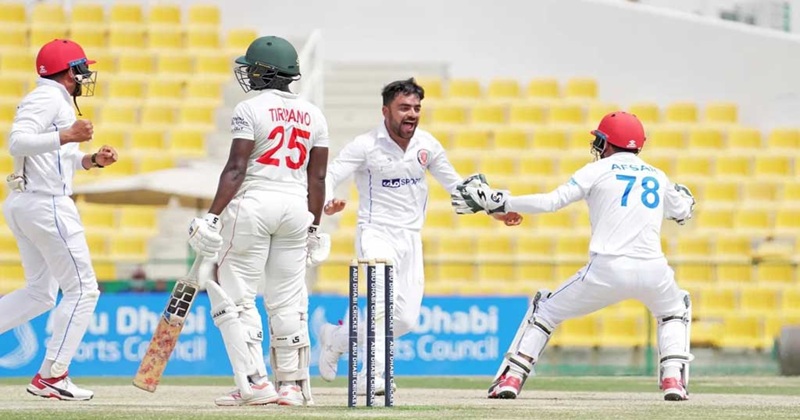 সতীর্থদের সঙ্গে উল্লাস করছেন রাশিদ খান (মাঝে)।